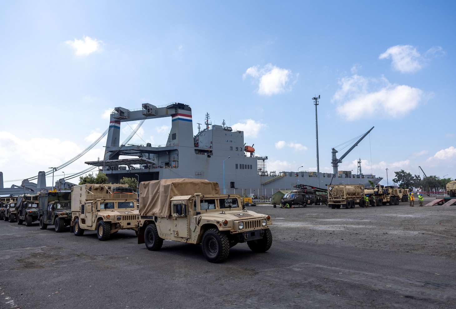 Military vehicles are staged near Military Sealift Command chartered ship MV Cape Hudson (T-AKR 5066) during an offload of equipment in support of exercise Super Garuda Shield 2024, at the Port of Banyuwangi, Indonesia Aug. 12. Super Garuda Shield, one of the largest multinational exercises in the Indo-Pacific region, continues to solidify the U.S.-Indonesia Major Defense Partnership Defense Cooperation Agreement and advances cooperation in support of a free and open Indo-Pacific region. (Navy photo by Grady T. Fontana)