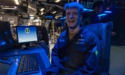 Operations Specialist 2nd Class Tristan Sharkey possess for photo in the combat information center aboard USS Wasp (LHD 1).