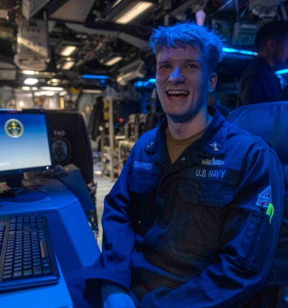 Operations Specialist 2nd Class Tristan Sharkey possess for photo in the combat information center aboard USS Wasp (LHD 1).