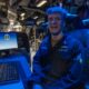 Operations Specialist 2nd Class Tristan Sharkey possess for photo in the combat information center aboard USS Wasp (LHD 1).