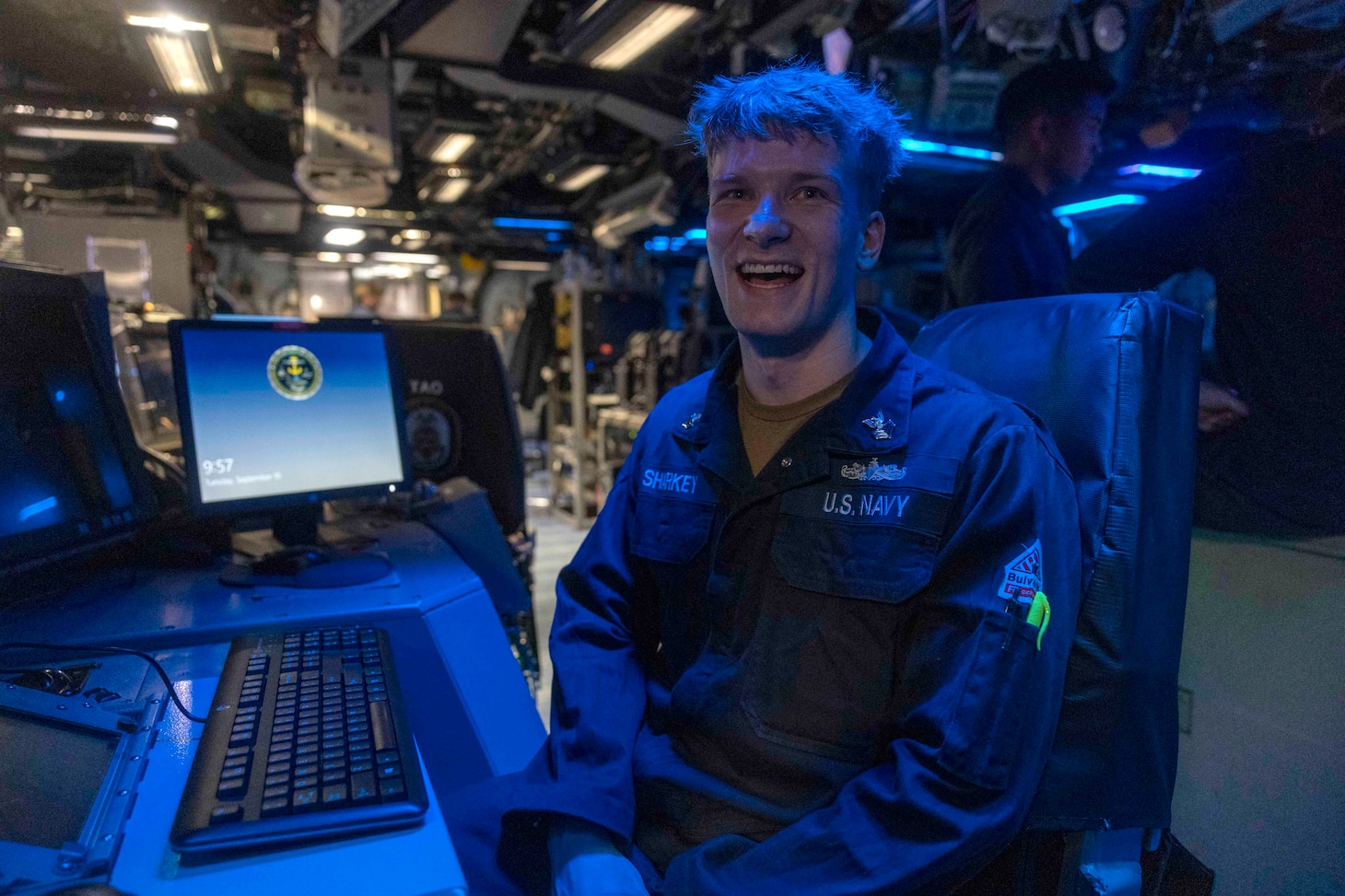 Operations Specialist 2nd Class Tristan Sharkey possess for photo in the combat information center aboard USS Wasp (LHD 1).