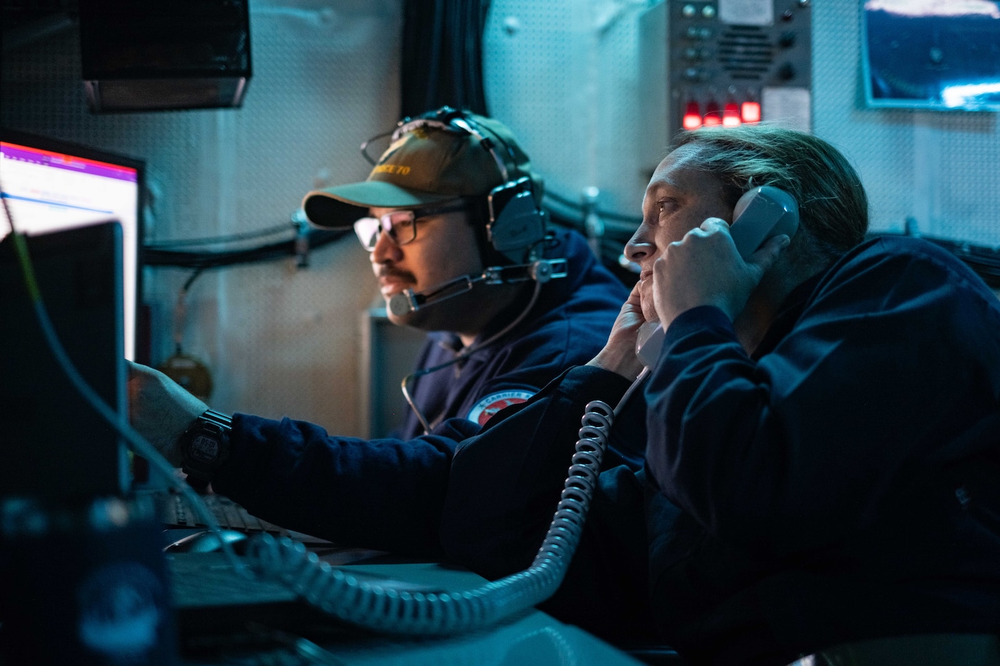 Cryptologic Technician (Technical) 1st Class Matthew Salazar, from Chicago, center, and Senior Chief Cryptologic Technician (Technical) Amy Woolston, from Jacksonville, North Carolina, both assigned to Commander, Task Force 70, embarked on U.S. 7th Fleet’s premiere forward-deployed aircraft carrier USS George Washington (CVN 73), maintain Carrier Strike Group 5 battlespace awareness while standing watch for the information warfare commander in the tactical flag command center while underway in the Pacific Ocean, during Keen Sword 25, Oct. 26.