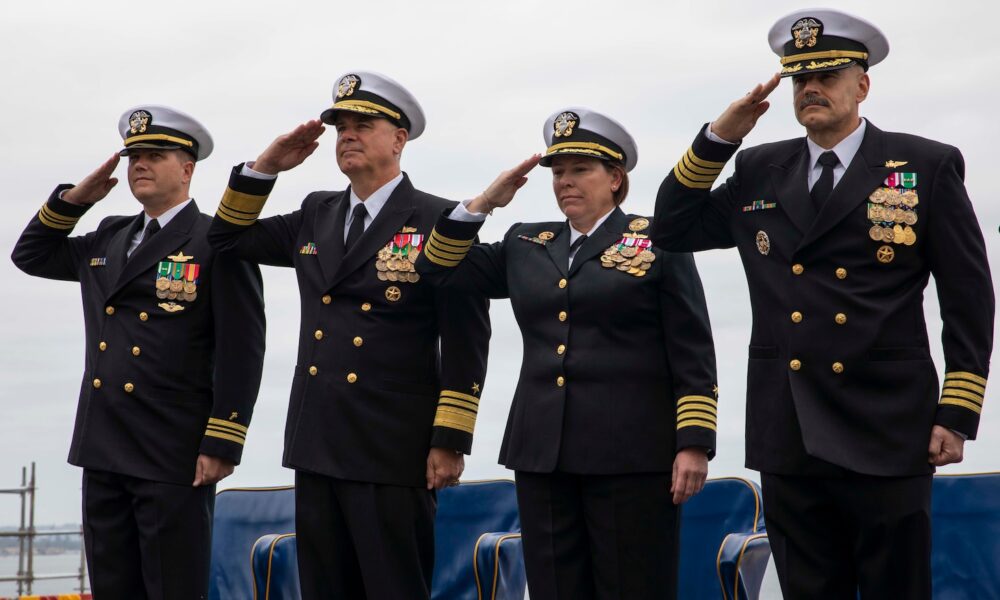 The official party salutes the national ensign aboard USS Makin Island (LHD 8) during a change of command ceremony at Naval Base San Diego.