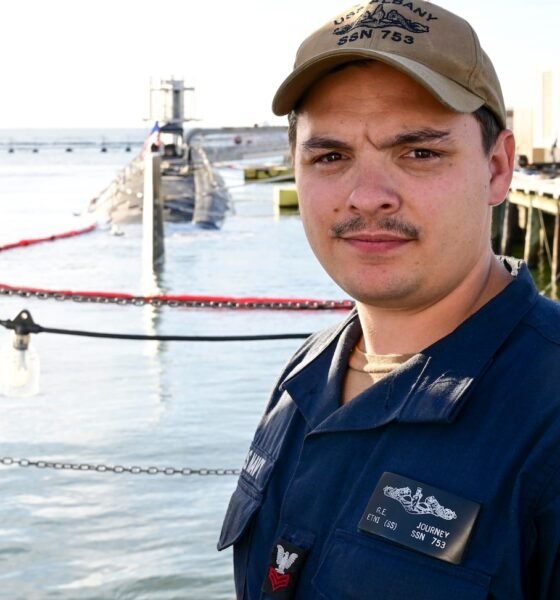 Sailor stands in front of a submarine