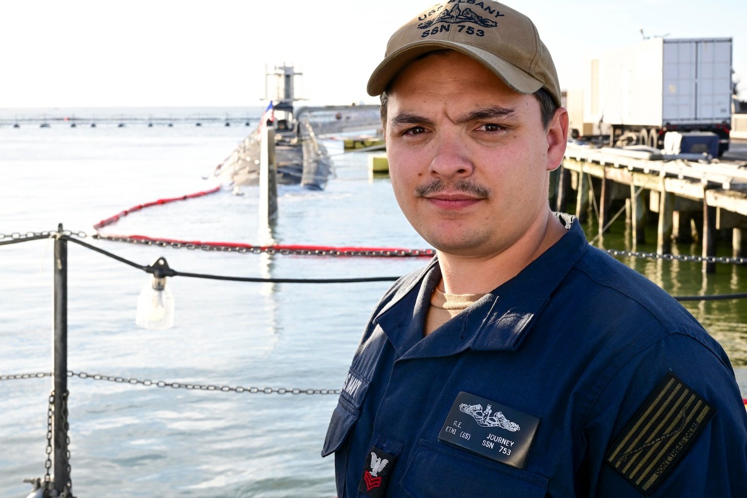 Sailor stands in front of a submarine