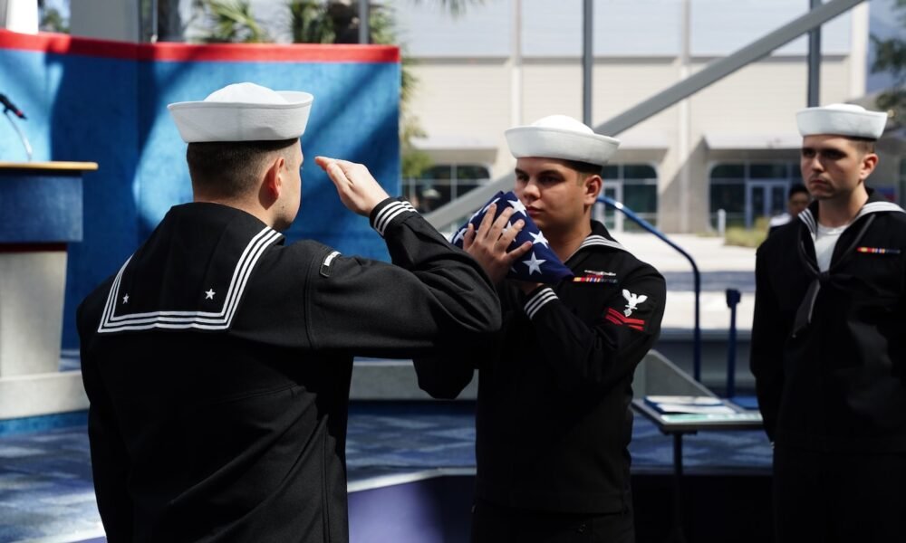 Sailors salute the ensign during a retirement ceremony in  Pensacola, Fla.