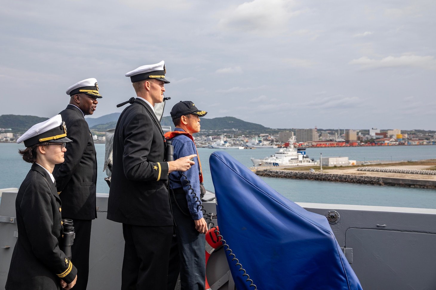 The Commanding Officer of the San Antonio-class amphibious transport dock ship USS San Diego (LPD 22), Capt. Timothy Carter (back left), stands alongside the Ishigaki harbor pilot and his bridge watch team as the ship arrives in Ishigaki, Japan, Feb. 26.